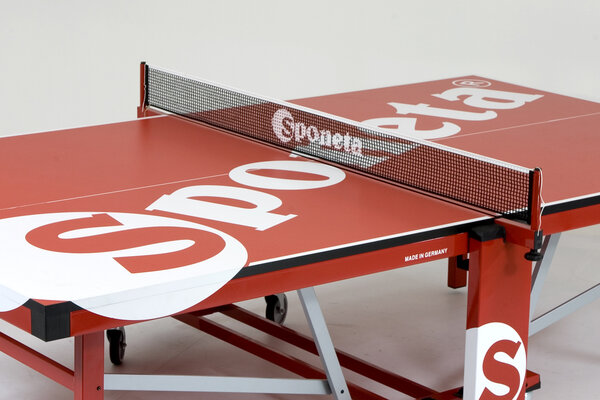 Tischtennisplatte, darauf ein Tischtennisnetz befestigt mit zusätzlicher Sponsorenwerbung.